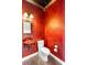 Unique powder room with red walls, a decorative sink, and ornate mirror, creating a bold and stylish statement at 762 Onyx Pkwy, Deland, FL 32724