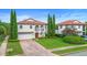 Two-story home with a tile roof, arched entry, manicured landscaping, and brick driveway at 762 Onyx Pkwy, Deland, FL 32724