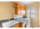 Well-lit laundry room with granite counters, wooden cabinets, and a front load washer at 762 Onyx Pkwy, Deland, FL 32724