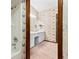 Bright bathroom featuring butterfly wallpaper, white vanity, and a shower-tub combination at 8 Rising Moon Trl, Ormond Beach, FL 32174