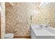 Bathroom with white vanity, sink, framed mirror, leaf wallpaper, and beige tile flooring at 8 Rising Moon Trl, Ormond Beach, FL 32174