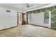 Spacious bedroom with light carpet, windows, a ceiling fan, and an attached bathroom with a wood door at 8 Rising Moon Trl, Ormond Beach, FL 32174