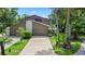 Exterior view of the house showcasing the driveway and tropical landscaping at 8 Rising Moon Trl, Ormond Beach, FL 32174