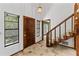 Foyer with a striking wooden staircase, stone floor, and bright, airy feel at 8 Rising Moon Trl, Ormond Beach, FL 32174