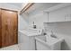 Bright laundry room features a washing machine, sink, and storage shelves at 8 Rising Moon Trl, Ormond Beach, FL 32174