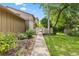 Tranquil walkway leading to the home with lush greenery and landscaping at 8 Rising Moon Trl, Ormond Beach, FL 32174