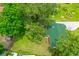 Aerial view of home with green roof nestled among lush greenery at 812 Faulkner St, New Smyrna Beach, FL 32168