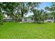 Expansive backyard with lush lawn and mature landscaping, perfect for outdoor living at 812 Faulkner St, New Smyrna Beach, FL 32168