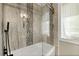 Elegant bathtub with shower with glass door and decorative tile detail at 812 Faulkner St, New Smyrna Beach, FL 32168