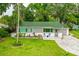 Charming home with well-manicured lawn and inviting front porch with chairs at 812 Faulkner St, New Smyrna Beach, FL 32168