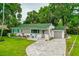 Charming home with well-manicured lawn and inviting front porch with chairs at 812 Faulkner St, New Smyrna Beach, FL 32168