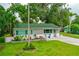 Charming home with well-manicured lawn and inviting front porch with chairs at 812 Faulkner St, New Smyrna Beach, FL 32168