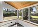 Bright sunroom featuring wood ceiling and large windows with backyard views and gray wood-look flooring at 812 Faulkner St, New Smyrna Beach, FL 32168