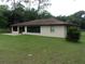Spacious backyard featuring a concrete patio, lush lawn, and mature trees at 871 Oak Tree Ln, Lake Helen, FL 32744