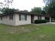 Classic single-story home with neutral stucco siding and dark trim around the windows at 871 Oak Tree Ln, Lake Helen, FL 32744