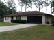 Classic single-story home with a two-car garage and a concrete driveway at 871 Oak Tree Ln, Lake Helen, FL 32744