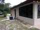 Home exterior with a modern AC unit, access door, and large picture windows at 871 Oak Tree Ln, Lake Helen, FL 32744