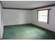 Spacious living room with large window and green carpet at 871 Oak Tree Ln, Lake Helen, FL 32744