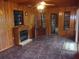 Living room with wood paneling, fireplace, tile floors, and doorway to another room at 871 Oak Tree Ln, Lake Helen, FL 32744