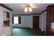Open-concept living room with a ceiling fan, green carpet, and a view into the kitchen area at 871 Oak Tree Ln, Lake Helen, FL 32744