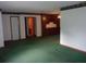 Large living room featuring green carpets, two entryways, and dark wood built-in cabinets at 871 Oak Tree Ln, Lake Helen, FL 32744