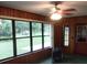 Living room with wood paneling, large windows, and green carpet with backyard view at 871 Oak Tree Ln, Lake Helen, FL 32744