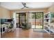 Bright living room boasts sliding doors to the yard, ceiling fan, and modern furnishings at 874 Commonwealth Ct, Casselberry, FL 32707
