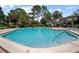 Community pool surrounded by lush landscaping and lounge chairs for relaxation at 874 Commonwealth Ct, Casselberry, FL 32707
