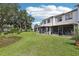Backyard featuring green grass, a pond, and views of the screened in patios at 903 Deer Springs Rd, Port Orange, FL 32129