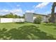 View of white picket fence, green lawn, and side of house with colorful shrubbery at 903 Deer Springs Rd, Port Orange, FL 32129