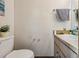 Powder room featuring a toilet, vanity with sink, and a charming decorative flower at 903 Deer Springs Rd, Port Orange, FL 32129