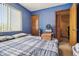Bedroom with blue walls, a window with blinds, and a plaid comforter on the bed at 903 Deer Springs Rd, Port Orange, FL 32129