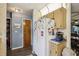 View of the kitchen showing a refrigerator and adjacent storage, with a glimpse into the hall at 903 Deer Springs Rd, Port Orange, FL 32129