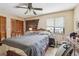 Bright bedroom featuring a ceiling fan, window, and wood-paneled closet doors at 903 Deer Springs Rd, Port Orange, FL 32129