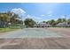 Fenced community tennis court surrounded by mature trees and landscaping at 903 Deer Springs Rd, Port Orange, FL 32129
