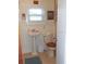 Cozy bathroom featuring classic fixtures, floral wallpaper, and natural light from the window at 942 Lemon Bluff Rd, Osteen, FL 32764