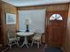 Cozy entryway featuring wood paneled walls, a round table, and vintage chairs at 942 Lemon Bluff Rd, Osteen, FL 32764