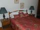 Comfortable bedroom featuring a wooden headboard bed with patterned bedding and matching nightstands at 942 Lemon Bluff Rd, Osteen, FL 32764