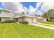Exterior view of townhome with garage and landscaped lawn at 961 S Lakewood Ter # C, Port Orange, FL 32127