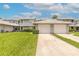 Well-maintained townhome exterior with a two-car garage and green lawn at 961 S Lakewood Ter # C, Port Orange, FL 32127