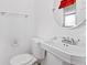 Bathroom featuring a toilet, sink, and round mirror at 10 Venetian Cir, Port Orange, FL 32127
