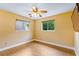 Bright bedroom features ceramic flooring, a ceiling fan, and two large windows at 10 Venetian Cir, Port Orange, FL 32127