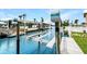 Modern boat lift on a canal featuring a wood dock and lush tropical landscaping at 10 Venetian Cir, Port Orange, FL 32127