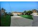 Single-story home with manicured lawn, attached garage, and long driveway to the street at 10 Venetian Cir, Port Orange, FL 32127