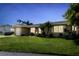 Well-maintained one story home with manicured lawn and mature landscaping under a blue sky at 10 Venetian Cir, Port Orange, FL 32127