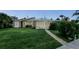 Exterior front view of a home with a well manicured lawn, shed, and screened-in porch at 10 Venetian Cir, Port Orange, FL 32127
