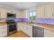 Updated kitchen featuring stainless appliances, granite counters, and modern white cabinetry at 10 Venetian Cir, Port Orange, FL 32127