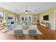 Bright living room with wood floors, ceiling fan, and sliding glass doors leading to the lanai at 10 Venetian Cir, Port Orange, FL 32127