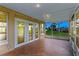 Covered patio with tile flooring leads to white-trimmed glass doors offering outdoor views at 10 Venetian Cir, Port Orange, FL 32127