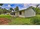 This is a nice backyard view of the house with a metal roof and a green lawn at 1017 Chippewa Trl, Daytona Beach, FL 32117